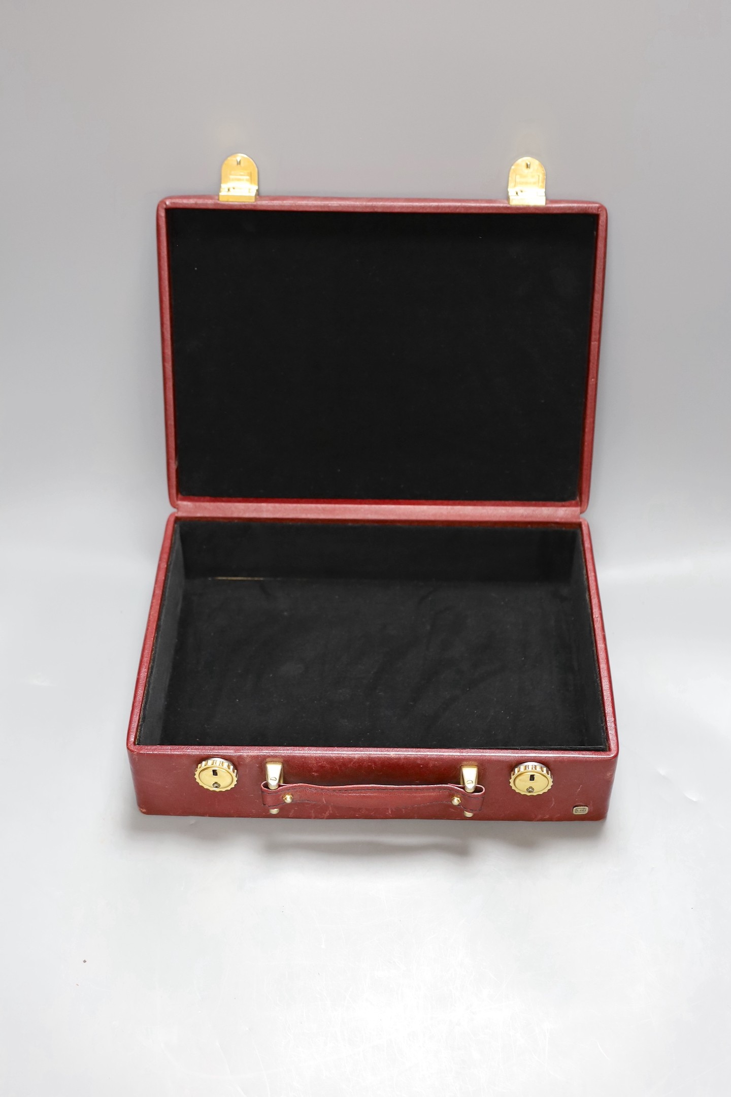 A small red leather mounted suitcase